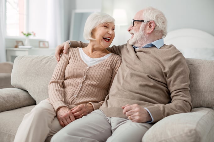  Senior couple create new year resolutions together while sitting on a couch. 