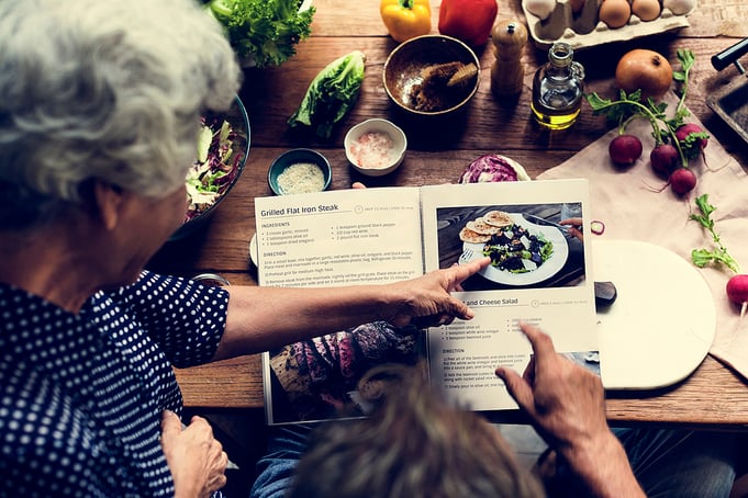 Senior woman points to a healthy winter recipe to make for dinner. 