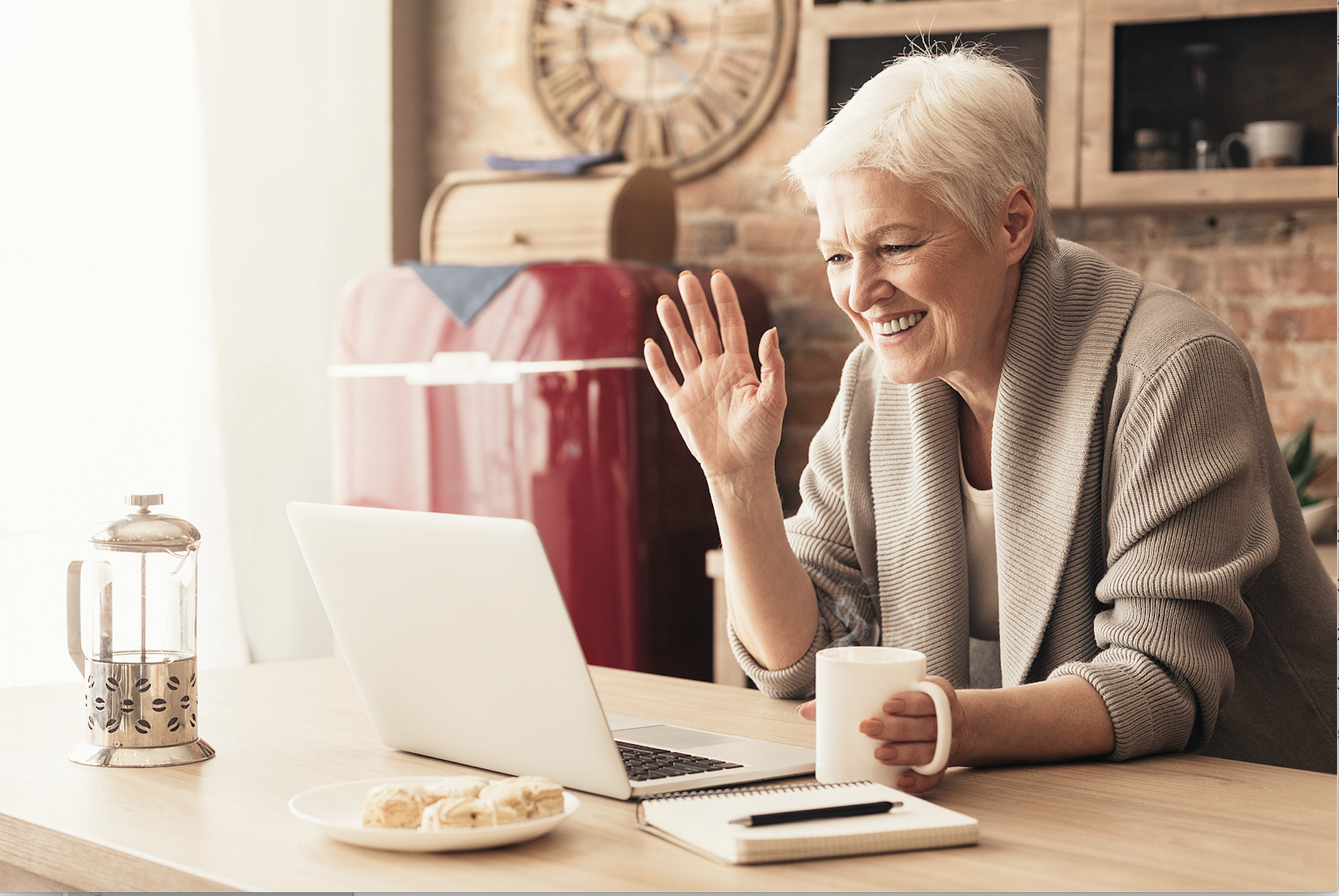 Happy senior woman visits virtually with loved ones. 